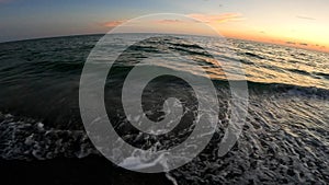 Golden hour beach swirling waves crashing