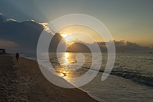 Golden hour, the sun's rays make their way through the clouds above the water surface