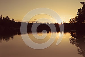 Golden hour sunset by a calm lake.