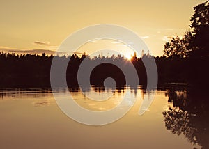 Golden hour sunset by a calm lake.