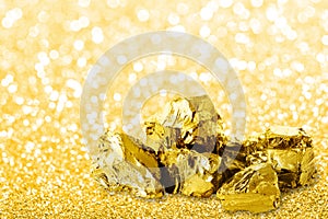 Golden ingots close up on golden dust glitter background.