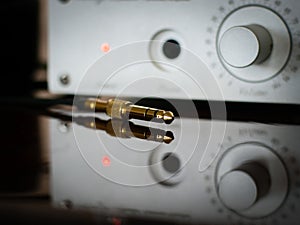 The golden jack connector against the background of a softly blurred audio amplifieron