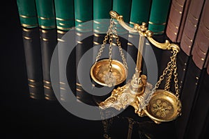 Golden justice scales in front of law books