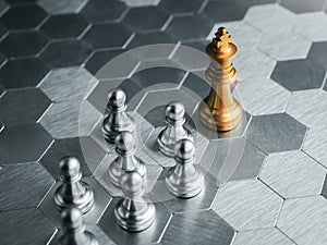 The golden king chess piece standing in front of silver pawn chess pieces on silver hexagon pattern board background.