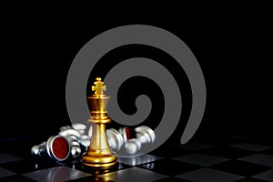 Golden king chess standing with chess pieces lying down on board isolate on black background