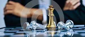 Golden king with silver chess piece on chess board game competition on business man background