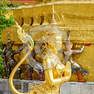 A Golden Kinnari statue in sawasdee action at the Temple of the Emerald Buddha (Wat Phra Kaew)
