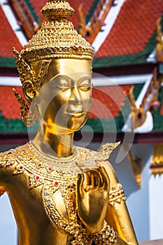 Golden Kinnari statue at Temple of Emerald Buddha (Wat Phra Kaew) in Grand Royal Palace. Bangkok, Thailand