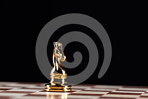 Golden knight chess figure on chessboard