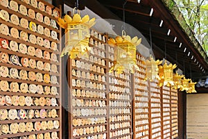 Golden lanterns hanging in front of mirror-shaped wooden preyer