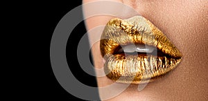 Golden lipstick closeup. Metal gold lips. Beautiful makeup. Sexy lips, bright paint on beautiful model girl`s mouth, close-up