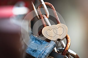 Golden lock with two hearts attached to a fence