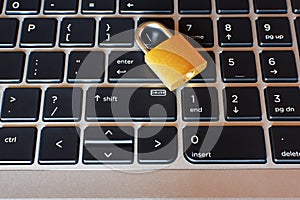 Golden locked padlock on laptop keyboard