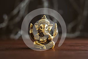 Golden lord Ganesha sculpture over blue illuminated background. Celebrate lord Ganesha festival