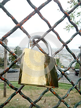Golden love padlock fix on a metallic net