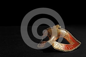 Golden Mardi Gras or Carnival mask isolated on a black background.