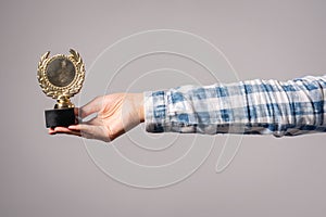 Golden medal award trophy in female hand