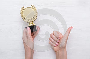 Golden medal trophy in hand.