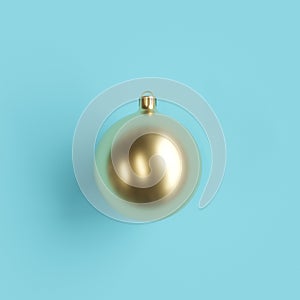 Golden mercury glass Christmas ornament on light blue background