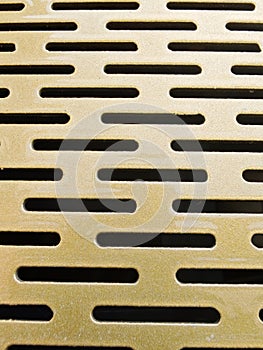 Golden Metal Surface with Oval Slot Pattern
