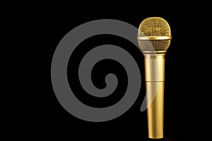 Golden microphone on black background.