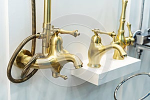 Golden modern shower taps in retro style. Plumbing trade in a household goods store