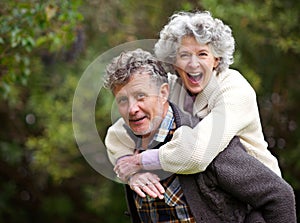 Golden moments together. Shot of a loving senior couple being playful outside.