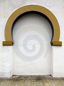 Golden Mudejar Arch on White Wall. Detail of the architecture of the bullring. Background and pattern