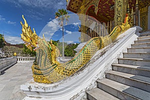 Golden naga King Cobras decorate teh stairs of Haw Pha Bang or Palace Chapel at the Royal Palace Museum in Luang Prabang, Laos photo