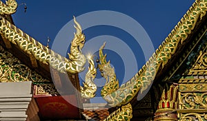 Golden Nagas on Buddhist temple roof.