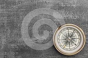 Golden navigational compass on a vintage gray background photo