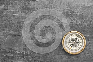 Golden navigational compass on a vintage gray background