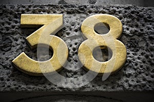 Golden number thirty eight on dark wall