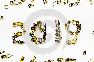 Golden numbers of confetti and foil tape. The new year 2019 on white background.