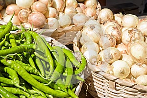 Golden onions and green pepper from organic agriculture exhibited in a market photo