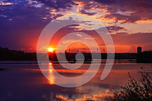 Romantic sunset on the water with symmetry of colorful clouds cumulonimbus