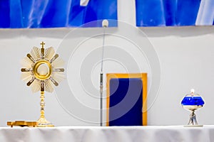 Golden Ostensory or Monstrance for Worship in a Catholic Church Ceremony with a Blue Oil Candle