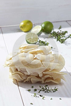 golden oyster mushrooms pleurotu citrinopileatus, limes and lemon thyme on wooden table.