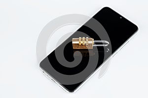 Golden padlock lies on a smartphone isolated on a white background. The concept of data protection in the phone