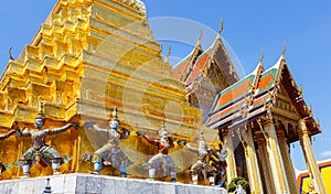 Golden pagoda with demon guardian at The Wat Phra Kaew or the temple of the Emerald Buddha within the grounds of the Grand Palace