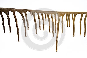 Golden paint drip trails on white paper background