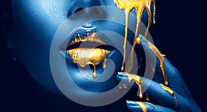 D'oro colore strisce gocce labbra un mano d'oro liquido gocce sul bellissimo le ragazze bocca creativo cosmetici 