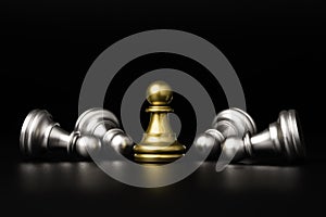 Golden pawn chess stand alone among silver pawns falling for business winner and competition strategy concept