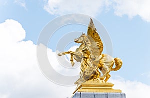 Golden pegasus statue at the Pont Alexander III bridge, Paris, a deck arch bridge that spans the Seine in Paris, France