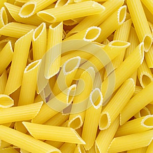 Golden penne rigate italian pasta texture background photo