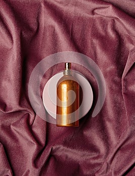 Golden perfume bottle and burgundy color fabric