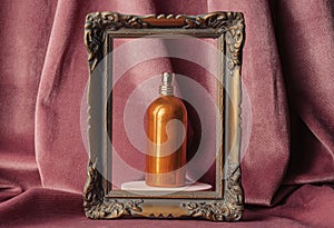 Golden perfume bottle in a frame