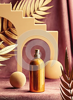 Golden perfume bottle next to geometric shapes and palm leaves