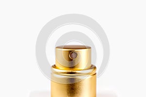Golden perfume spray cap on light background close up with copy space.