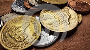 Golden Peso coin, with the Cabildo of Buenos Aires building, and a Golden Cruzeiro coin, with BrazilÃ¢â¬â¢s map, with old coins. photo